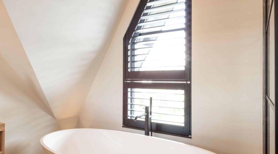 Vrijstaand bad mat wit, zwarte shutters badkamer