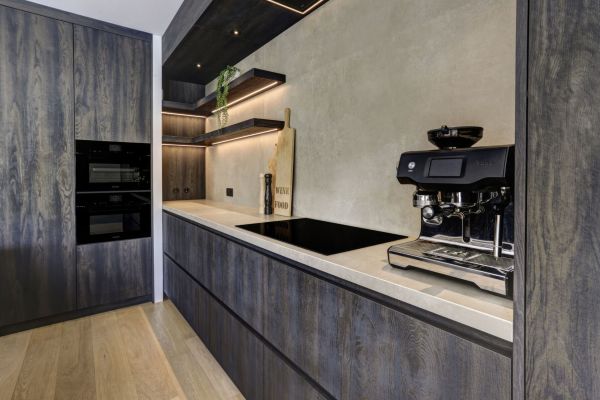 Keuken uitgevoerd in Bruciato hout met een zandkleurig keramiek werkblad