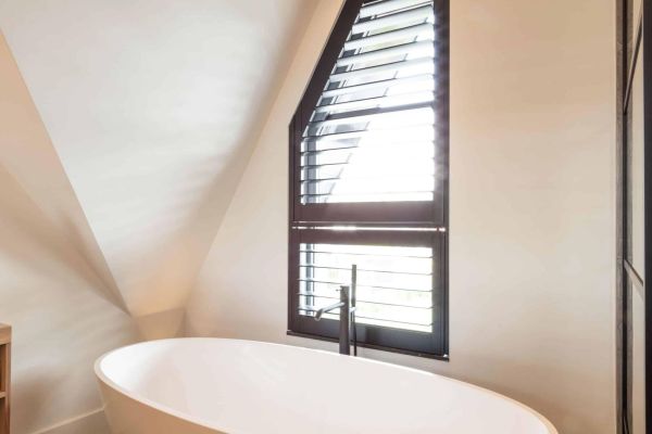 Vrijstaand bad mat wit, zwarte shutters badkamer