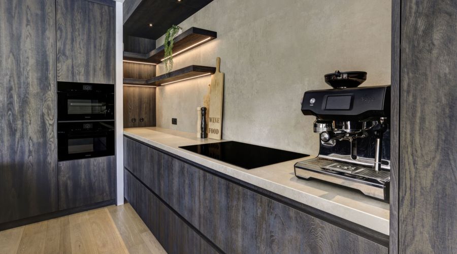 Keuken uitgevoerd in Bruciato hout met een zandkleurig keramiek werkblad